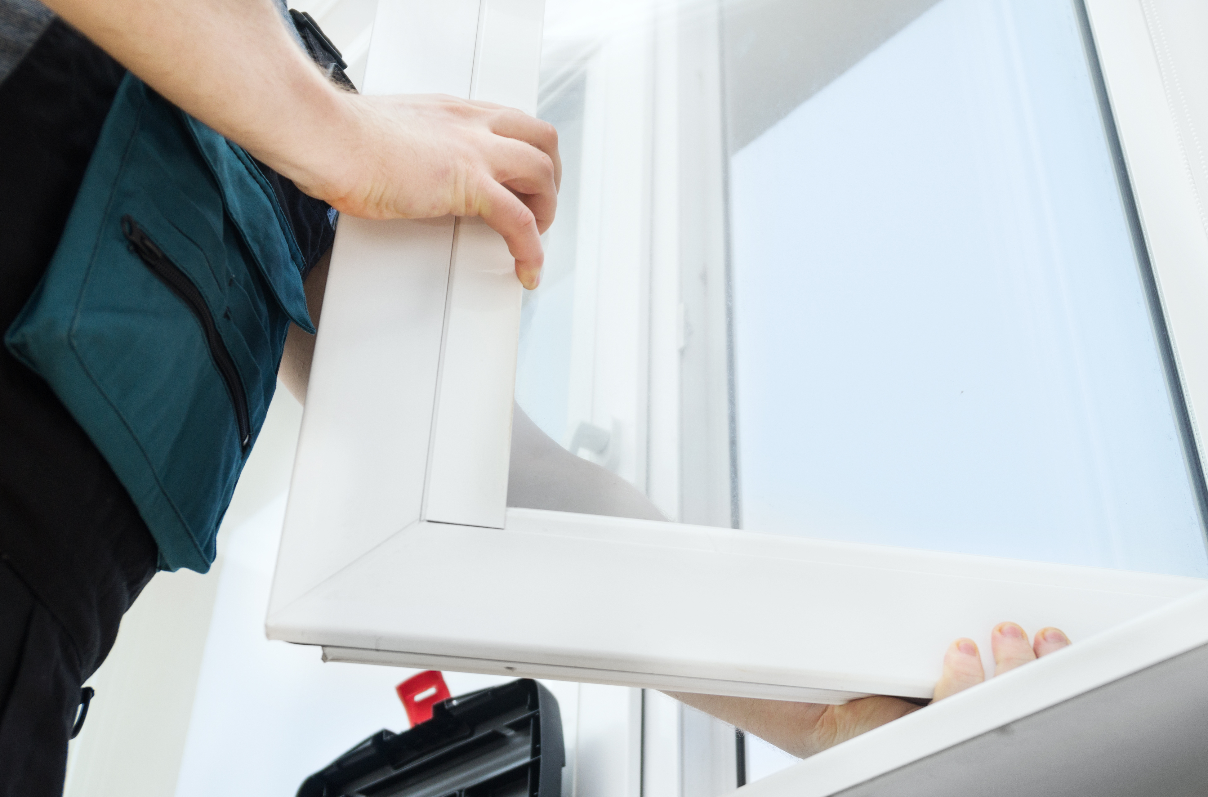 close up of a person replacing a window on a home